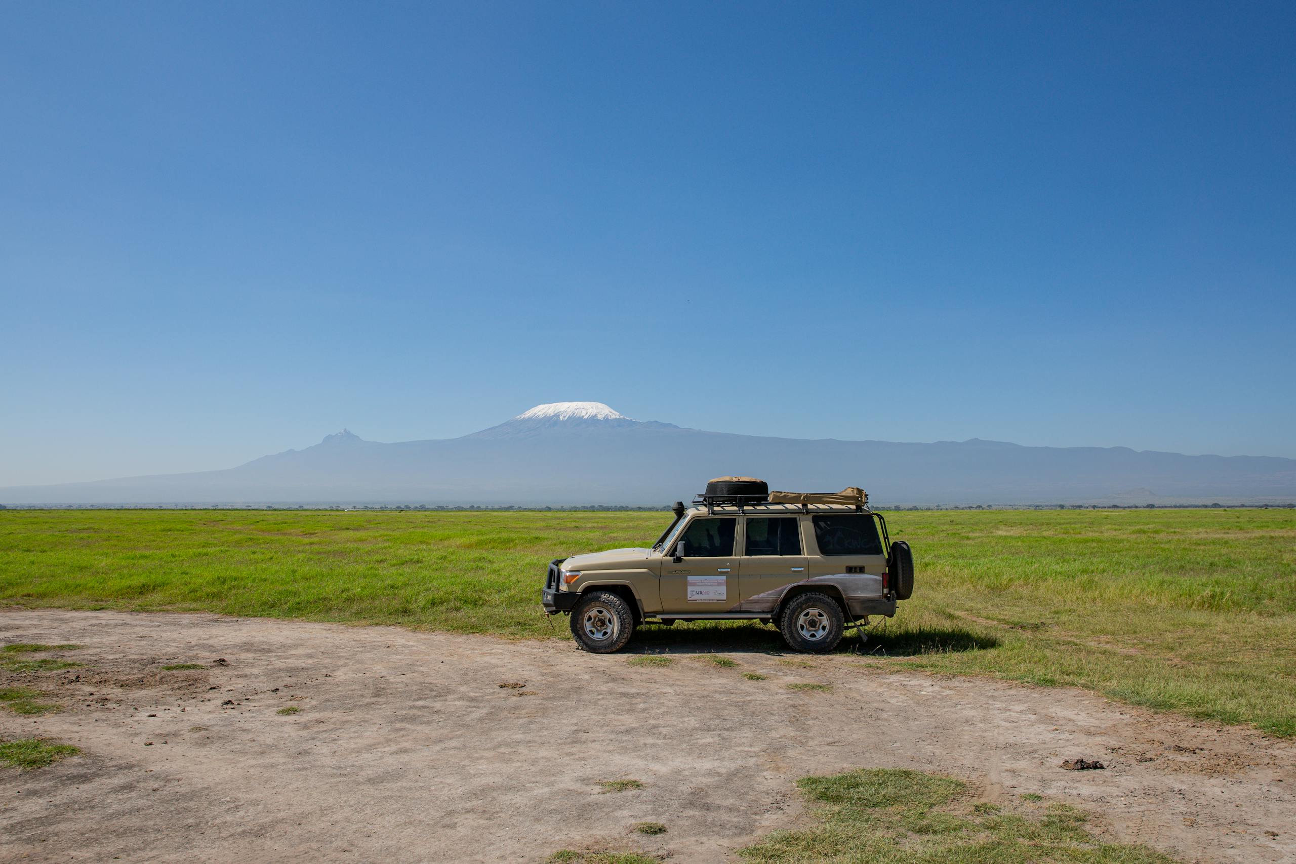 4x4 Car Staying on Savannah with the Mount Kilimanjaro in the Background